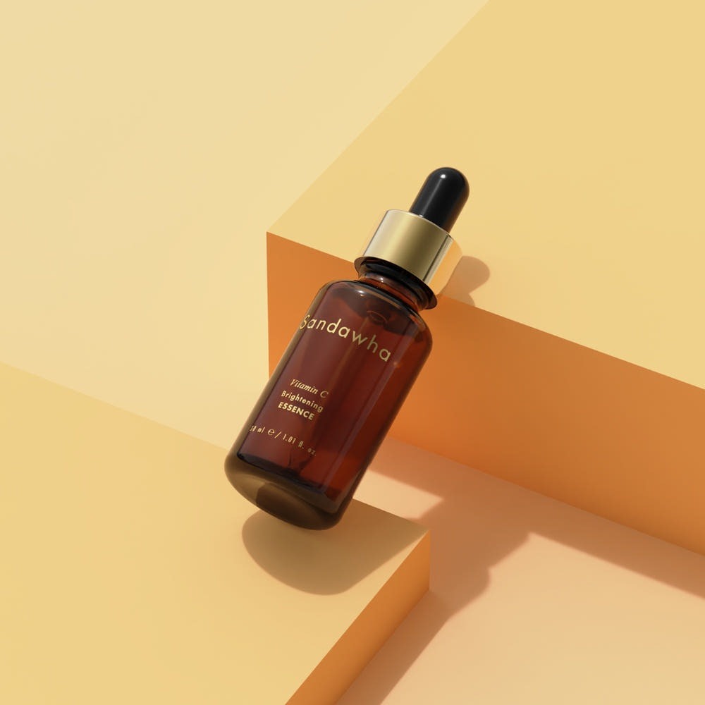 SANDAWHA Vitamin C Whitening Essence 30ml, flacon compte-gouttes sur décor géométrique, style solaire, marque SANDAWHA