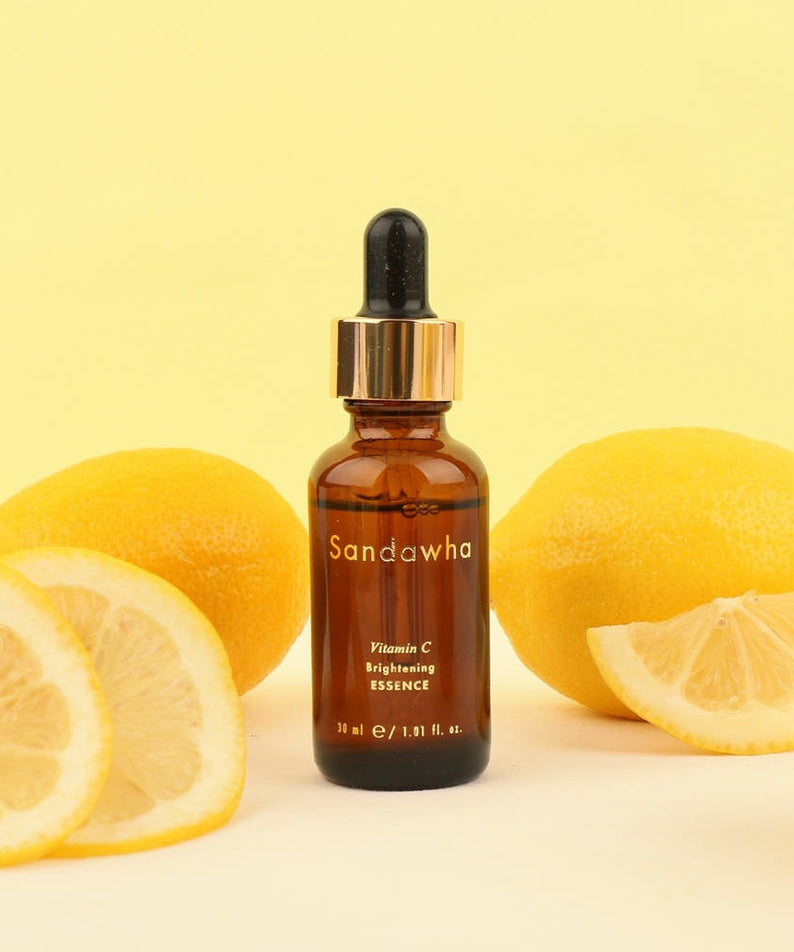 SANDAWHA Vitamin C Whitening Essence 30ml, flacon sur fond jaune avec citrons, mise en scène beauté