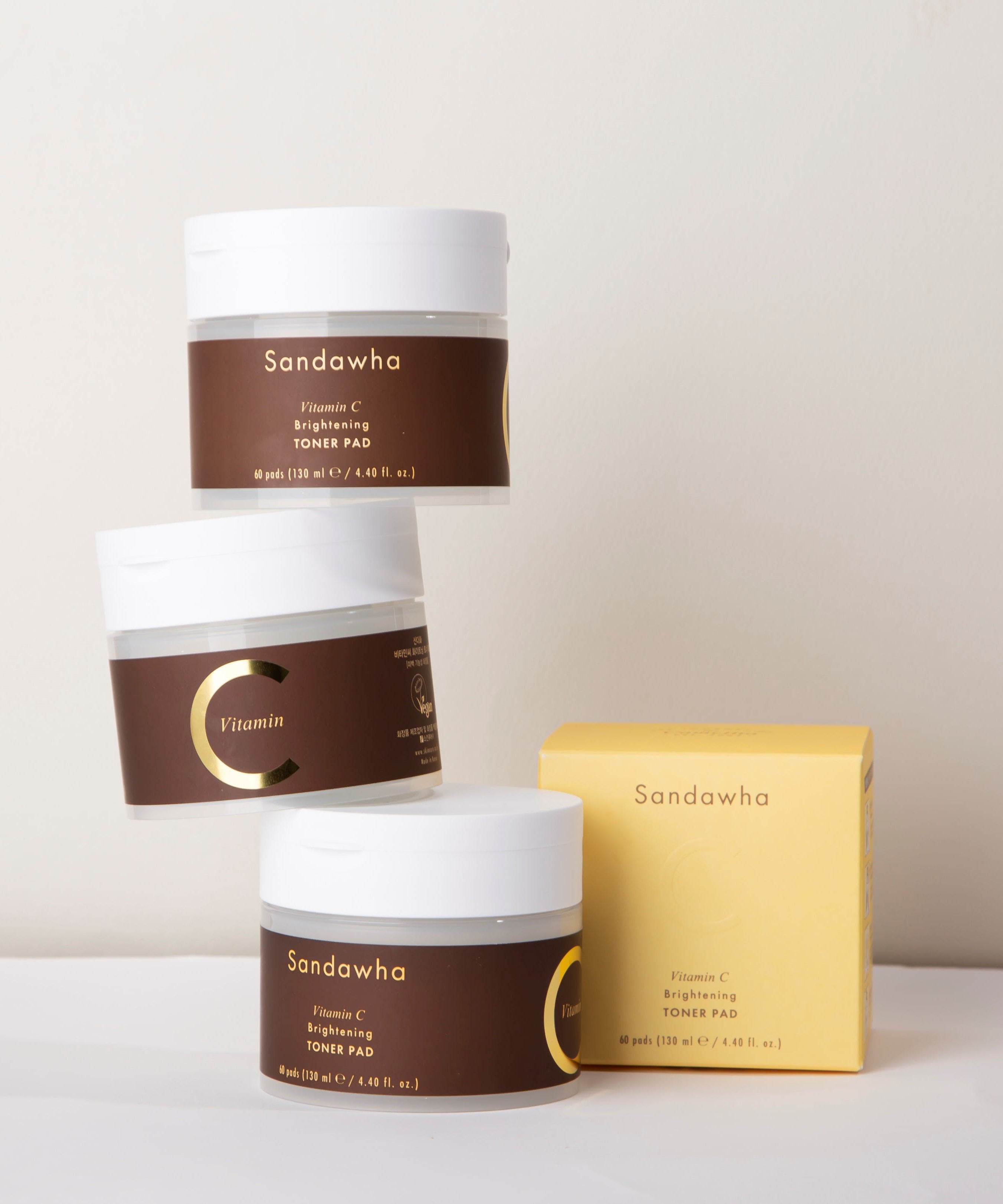 SANDAWHA Vitamin C Whitening Toner pad 60 Sheets, marque Sandawha, pots et boîte sur fond clair, packaging cosmétique.