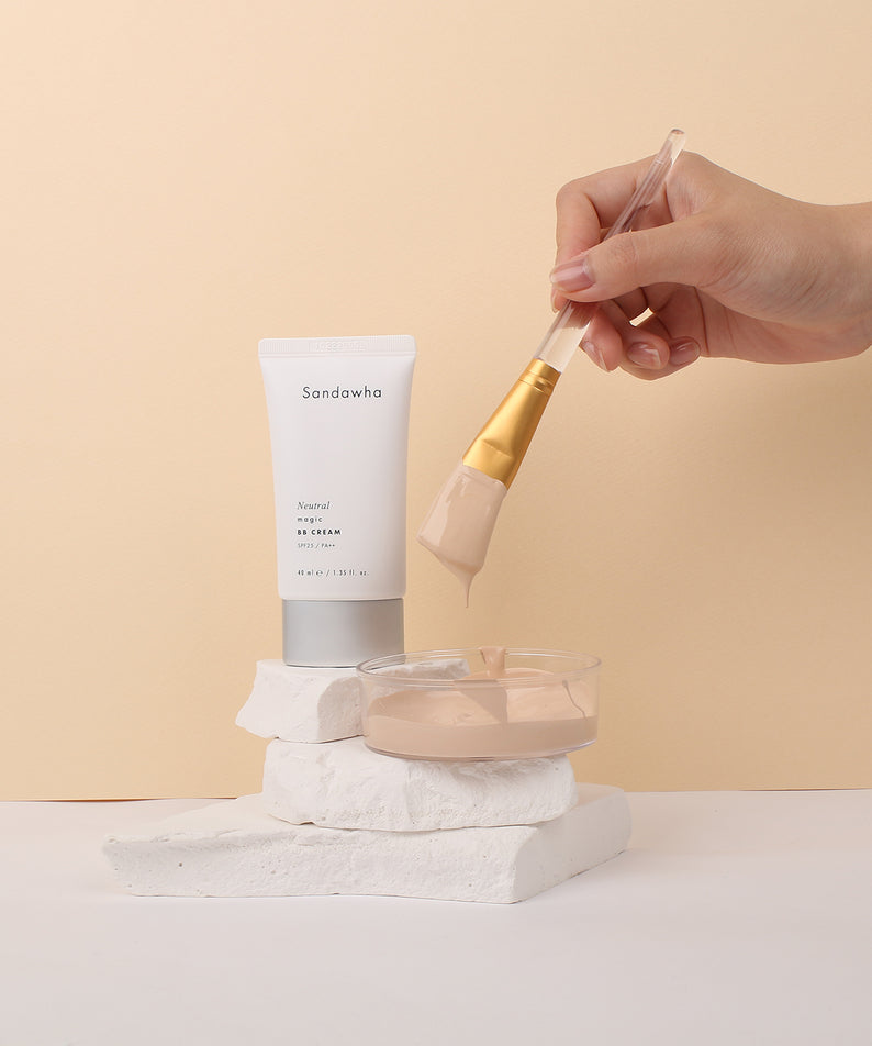 Décris l'image en français : SANDAWHA Neutral Magic BB Cream SPF25 PA++ 40ml, tube sur fond beige, main applique une crème.
