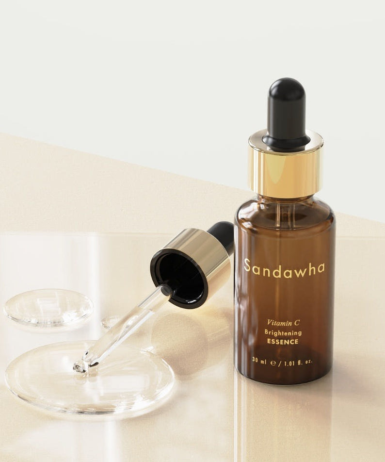 Flacon de SANDAWHA Vitamin C Whitening Essence 30ml sur une surface brillante, avec une pipette ouverte à côté.