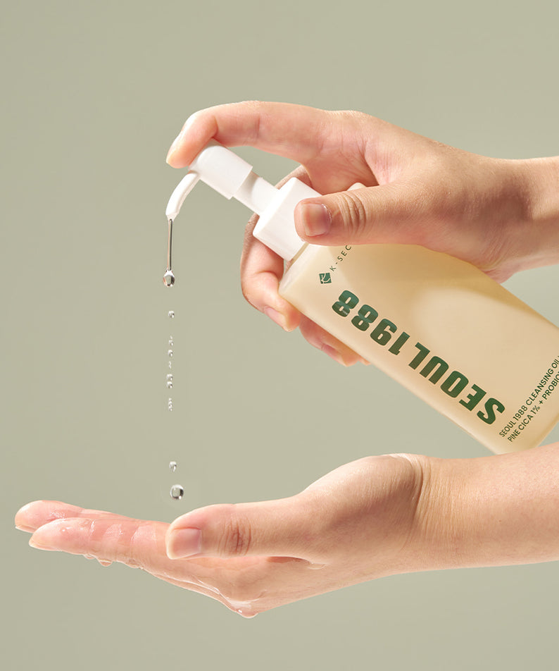 SEOUL 1988 Pine Cica Cleansing Oil 200ml, huile nettoyante de la marque, mains avec gouttes sur fond clair.