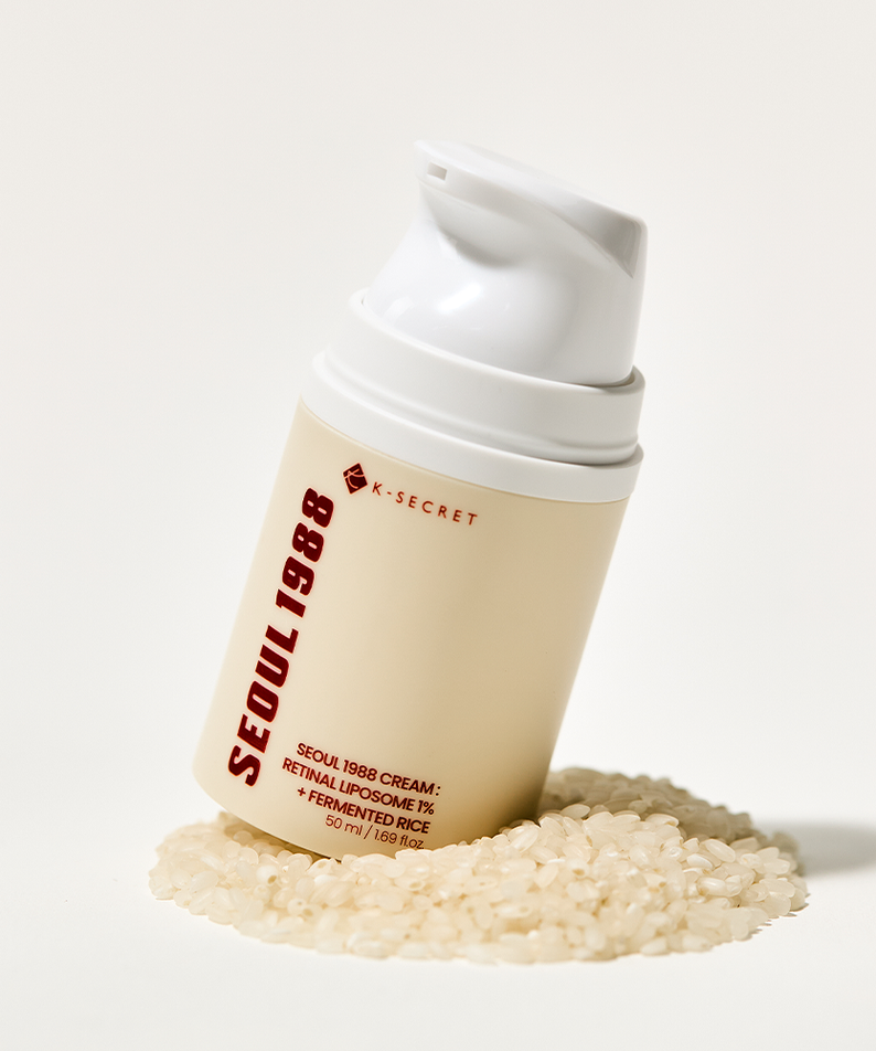 Décris l'image en français : SEOUL 1988 Retinal Fermented Rice Cream 50ml, flacon blanc sur riz fermenté, marque K-Secret.