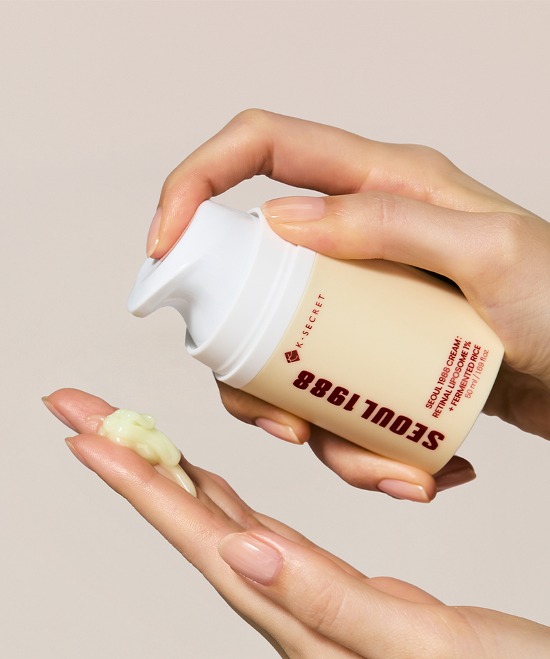 SEOUL 1988 Retinal Fermented Rice Cream 50ml, main appliquant la crème sur la peau, pot blanc beige, contexte beauté.