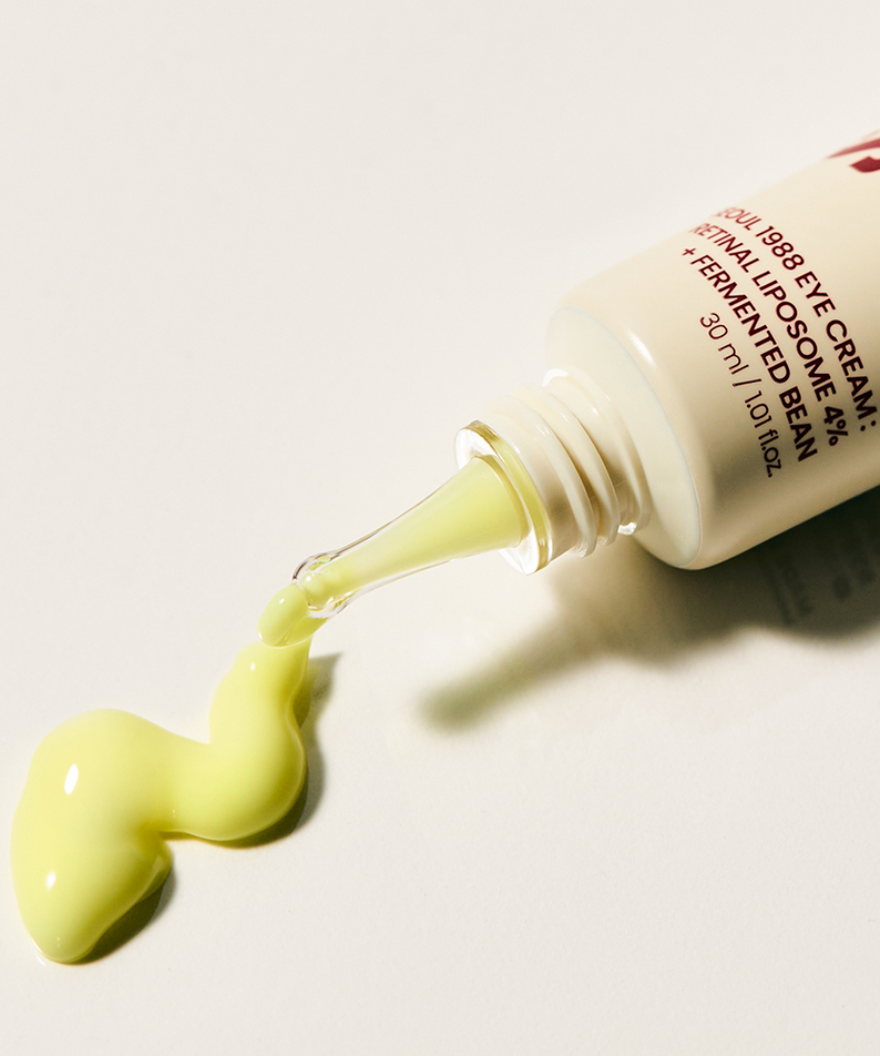 Décris l'image en français : SEOUL 1988 Retinal Fermented Soybean Eye Cream 30ml, marque SEOUL 1988, tube verse crème jaune.