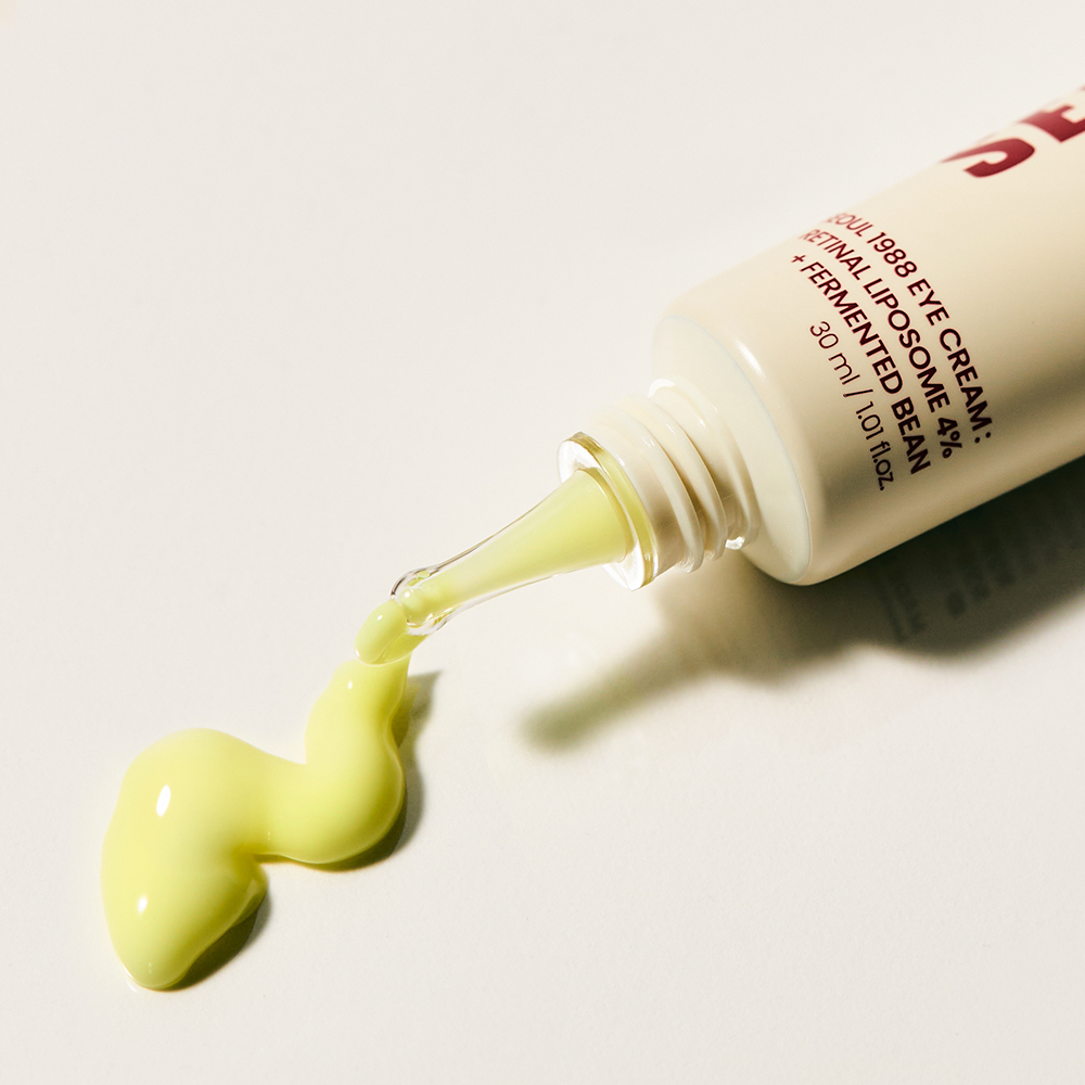Décris l'image en français : SEOUL 1988 Retinal Fermented Soybean Eye Cream 30ml, marque SEOUL 1988, tube verse crème jaune.