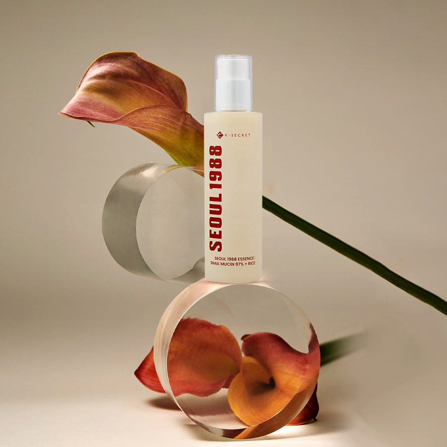 SEOUL 1988 Snail 97 Essence 100ml de marque SEOUL 1988, flacon sur fond beige avec escargots décoratifs.