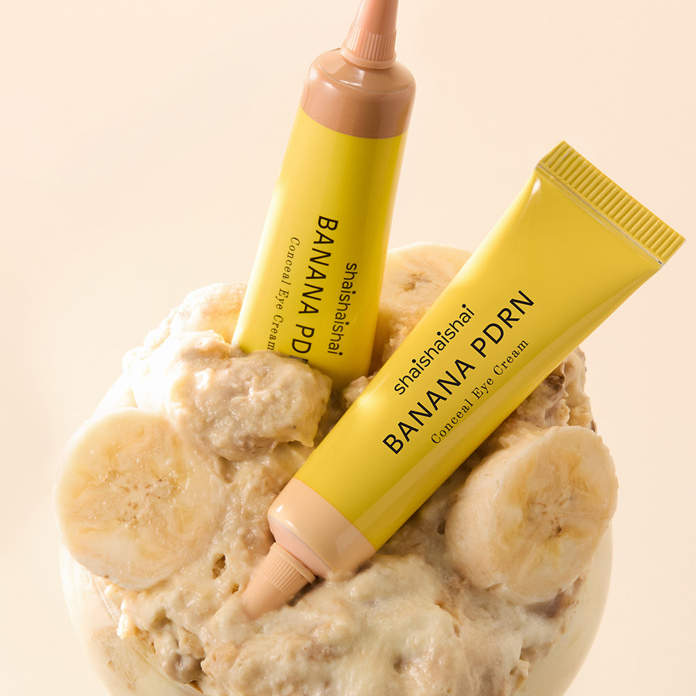 SHAISHAISHAI Banana PDRN Conceal Eye Cream 15ml, tubes jaunes sur fond beige avec tranches de banane, visuel produit