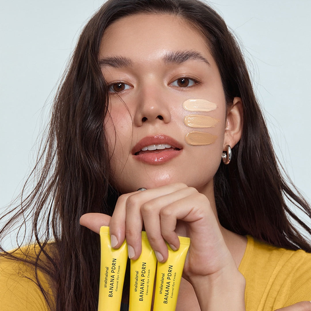 SHAISHAISHAI Banana PDRN Conceal Eye Cream 15ml : tube et femme appliquant le soin, maquillage naturel, fond clair.