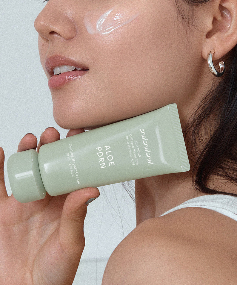 Femme tenant le SHAISHAISHAI [1+] Aloe PDRN Cooling Repair Cream 50ml, crème rafraîchissante avec de l'aloès pour une peau apaisée.
