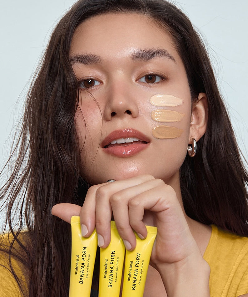 SHAISHAISHAI Banana PDRN Conceal Eye Cream 15ml : tube et femme appliquant le soin, maquillage naturel, fond clair.