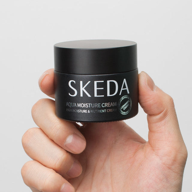 SKEDA Aqua Moisture Cream 50g de la marque SKEDA, pot crème hydratante tenu dans la main sur fond clair.