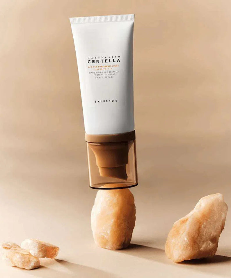 SKIN1004 Madagascar Centella Air-fit Sunscreen Light 50ml, tube crème solaire SKIN1004 sur fond beige, en studio.
