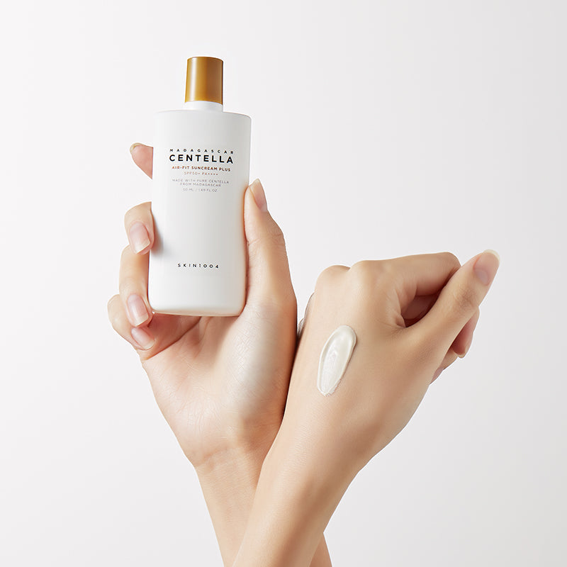 SKIN1004 Madagascar Centella Air-fit Sunscreen Plus 50ml, flacon crème solaire sur mains, marque SKIN1004, fond clair.