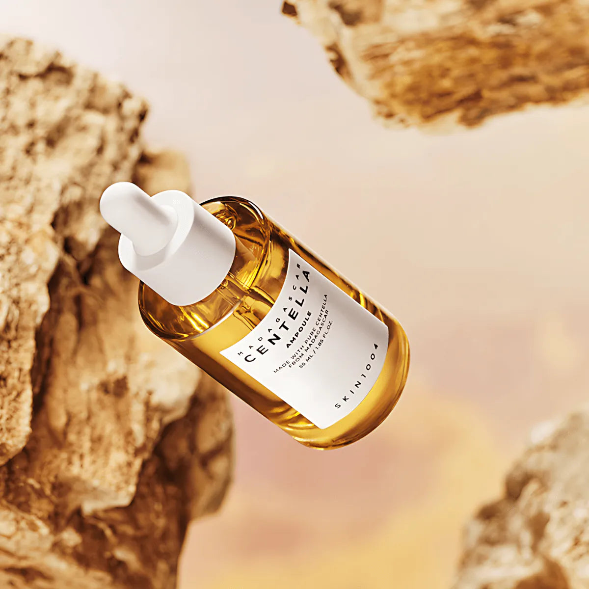 SKIN1004 Madagascar Centella Ampoule 55ml, flacon d’ampoule en verre ambre avec goutte blanche sur fond rocheux.
