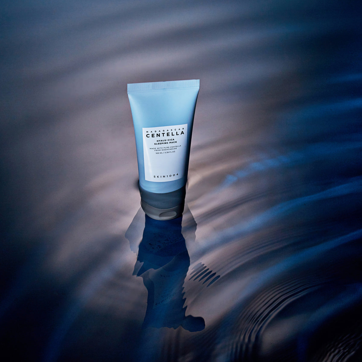 SKIN1004 Madagascar Centella Hyalu-Cica Acid Sleeping Pack 100ml : tube crème sur fond bleu, esthétique nuit, ambiance sérum.