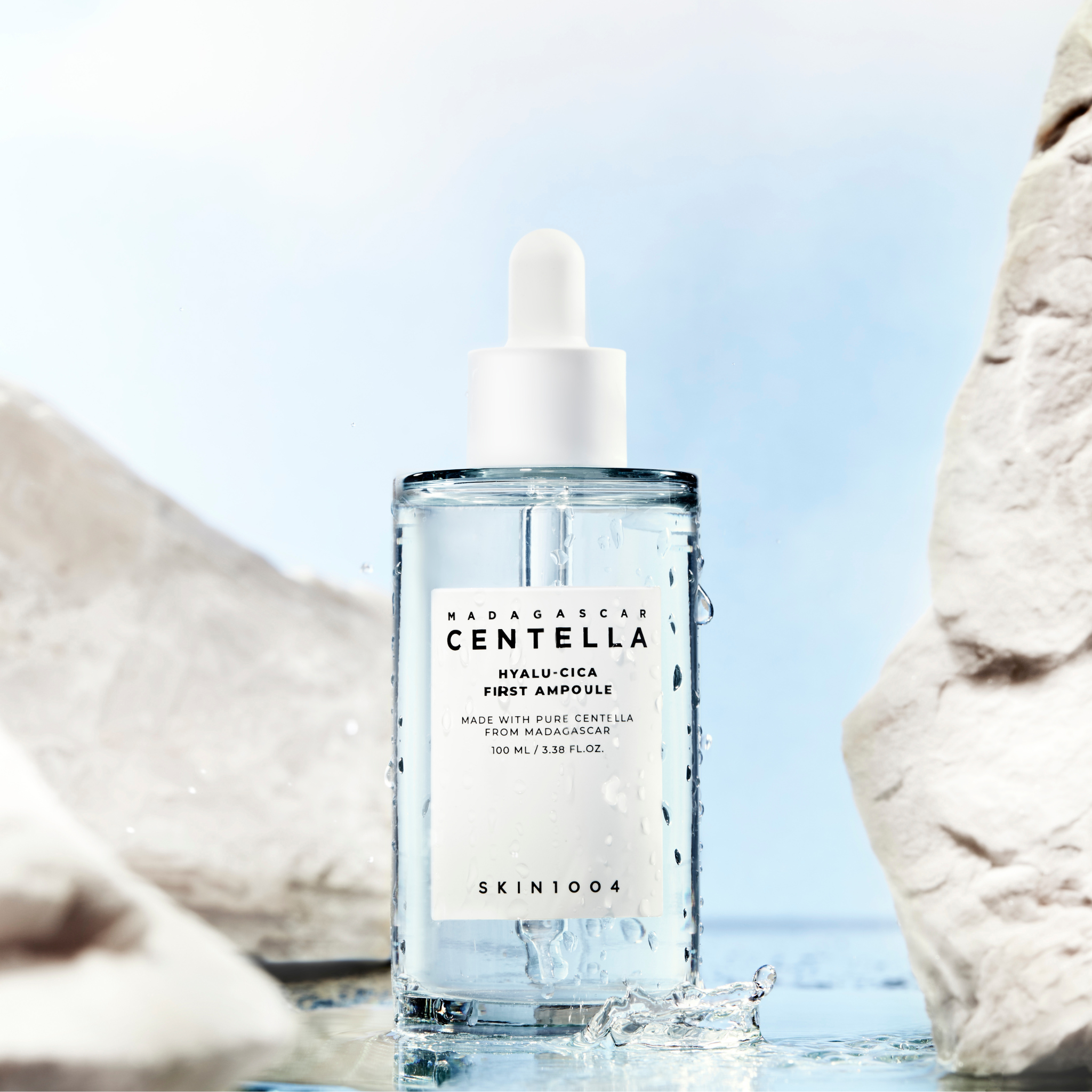 SKIN1004 Madagascar Centella Hyalu-Cica First Ampoule 100ml de SKIN1004, flacon sur fond plage avec rochers et eau