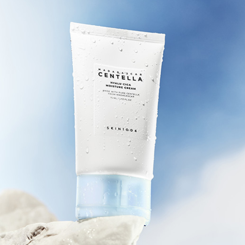 SKIN1004 Madagascar Centella Hyalu-Cica Moisture Cream 75ml de SKIN1004, tube crème sur fond bleu et serviette.
