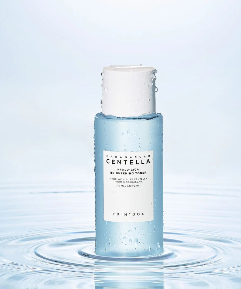 SKIN1004 Madagascar Centella Hyalu-Cica Radiance Toner 210ml, marque SKIN1004, flacon sur fond bleu, gouttes d’eau.