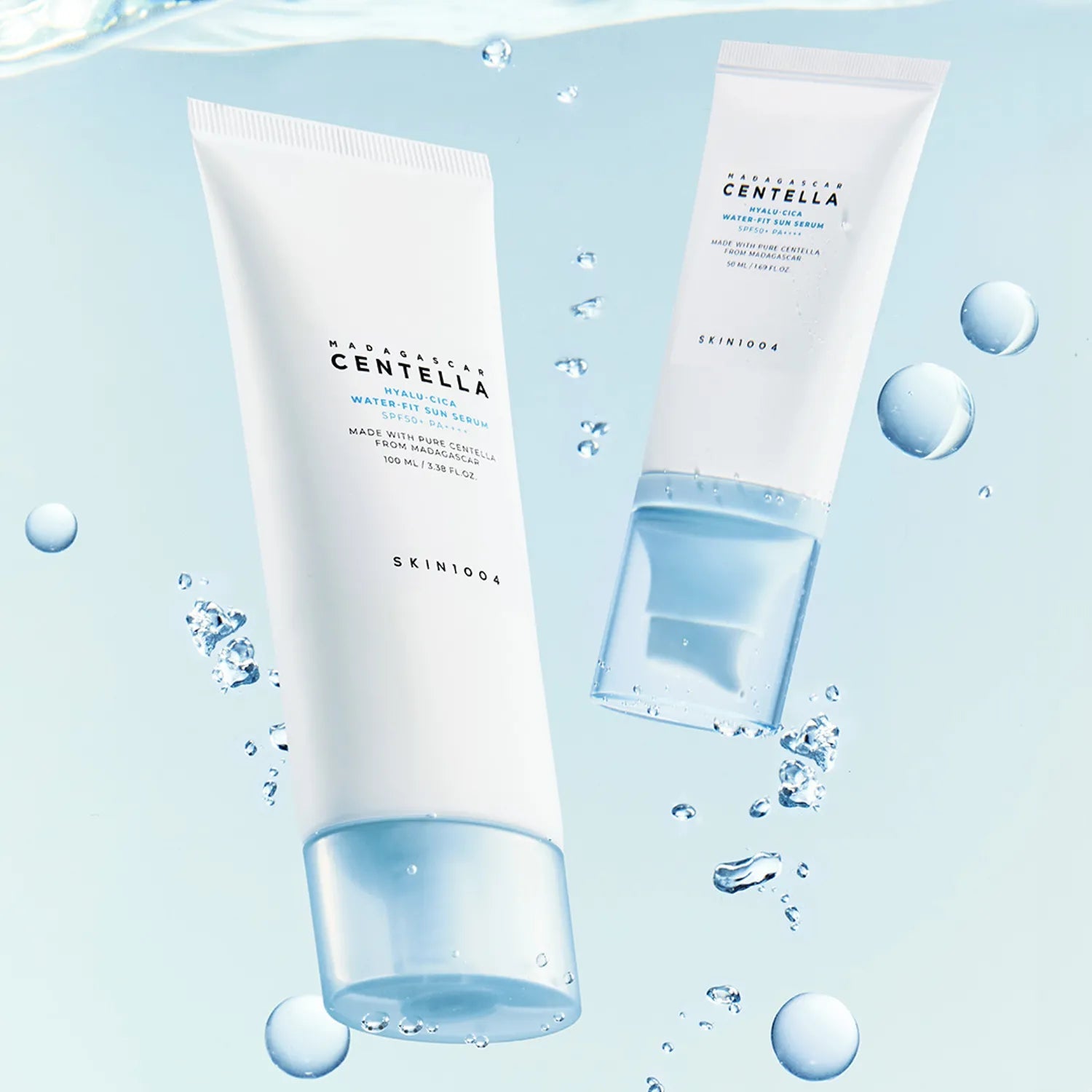 SKIN1004 Madagascar Centella Hyaluronic Acid Water-Fit Sun Serum 100ml de SKIN1004, flacons sur fond bleu avec gouttes d’eau