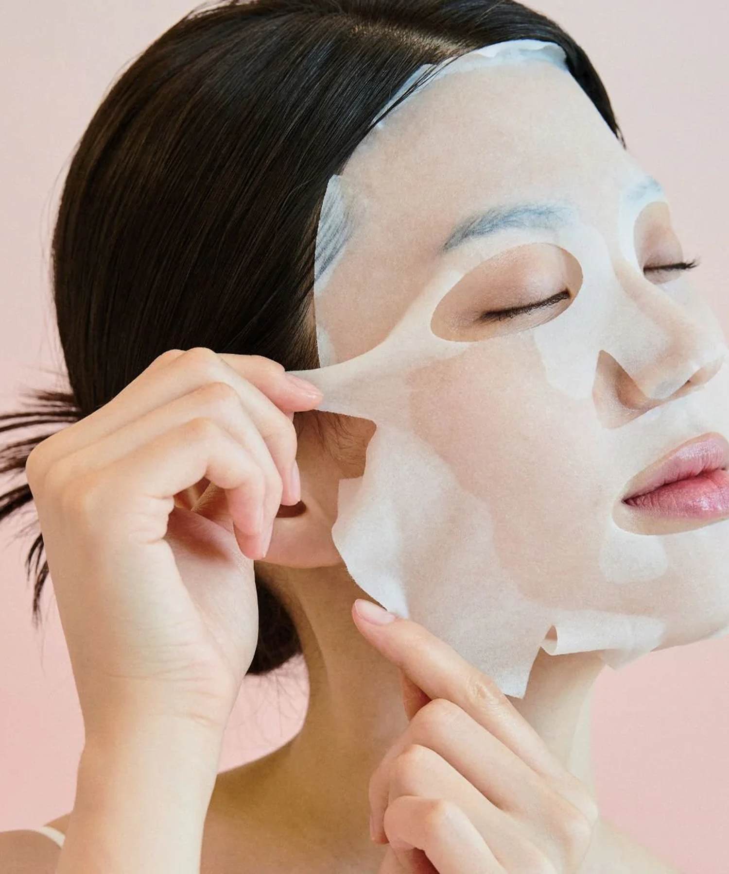 SKIN1004 Madagascar Centella Pore-Melting Clarifying Mask 23ml [5 sheets] : femme au masque visage, pack SKIN1004 sur fond rose.