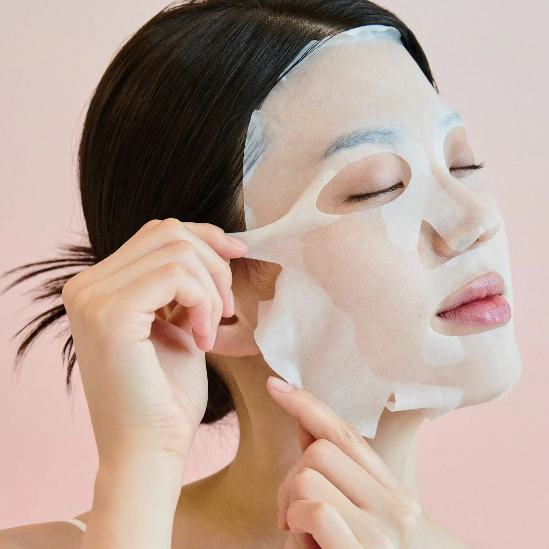 SKIN1004 Madagascar Centella Pore-Melting Clarifying Mask 23ml [5 sheets] : femme au masque visage, pack SKIN1004 sur fond rose.
