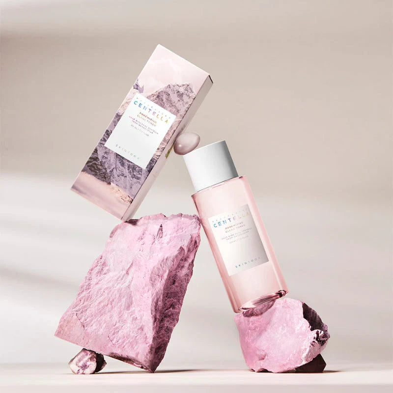 SKIN1004 Madagascar Centella Poremizing Clear Toner 210ml de la marque SKIN1004, flacon rose et textures de centella, fond clair.