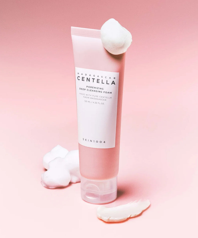 SKIN1004 Madagascar Centella Poremizing Deep Cleansing Foam 125ml en flacon crème sur fond rose, avec mousse.