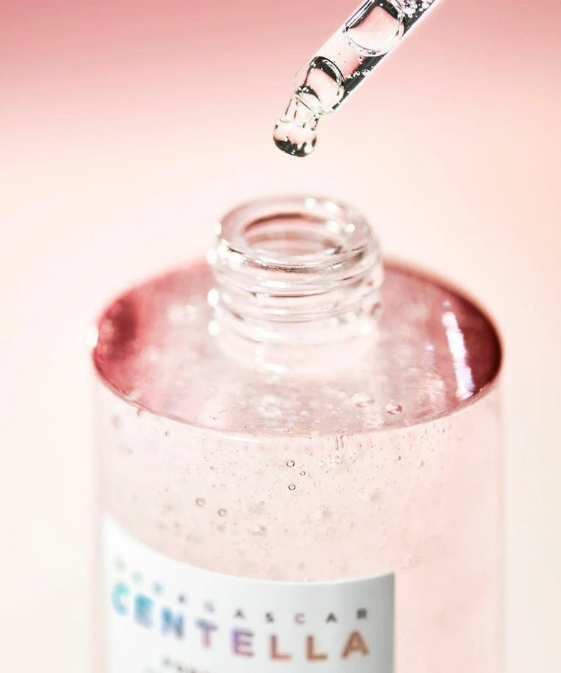 SKIN1004 Madagascar Centella Poremizing Fresh Ampoule 100ml, flacon gouttes de sérum, goutte-pipette sur fond rose.