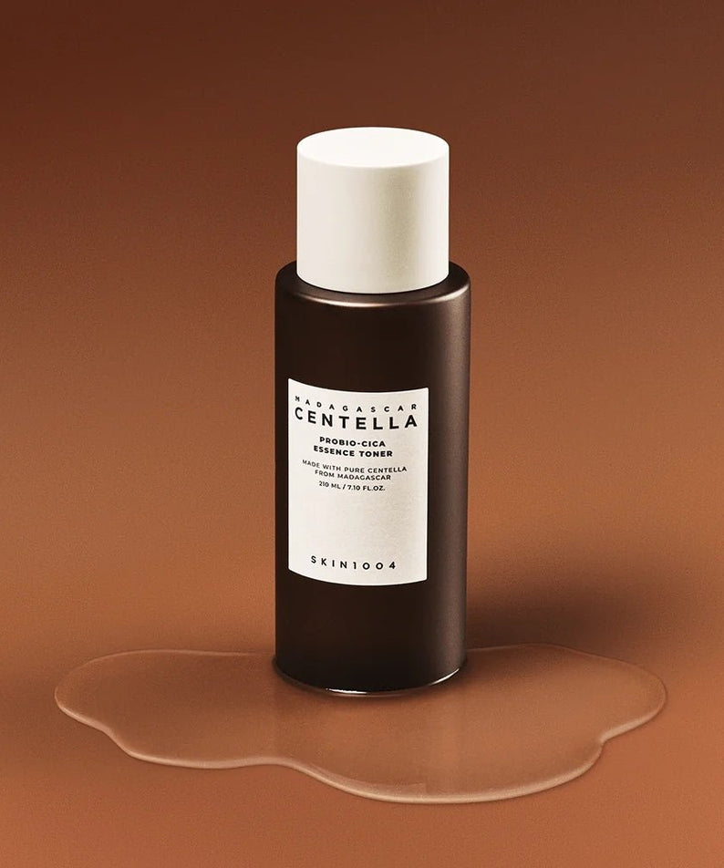SKIN1004 Madagascar Centella Probio-cica Essence Toner 210ml, flacon sur fond brun chaud, peau hydratée, marque SKIN1004
