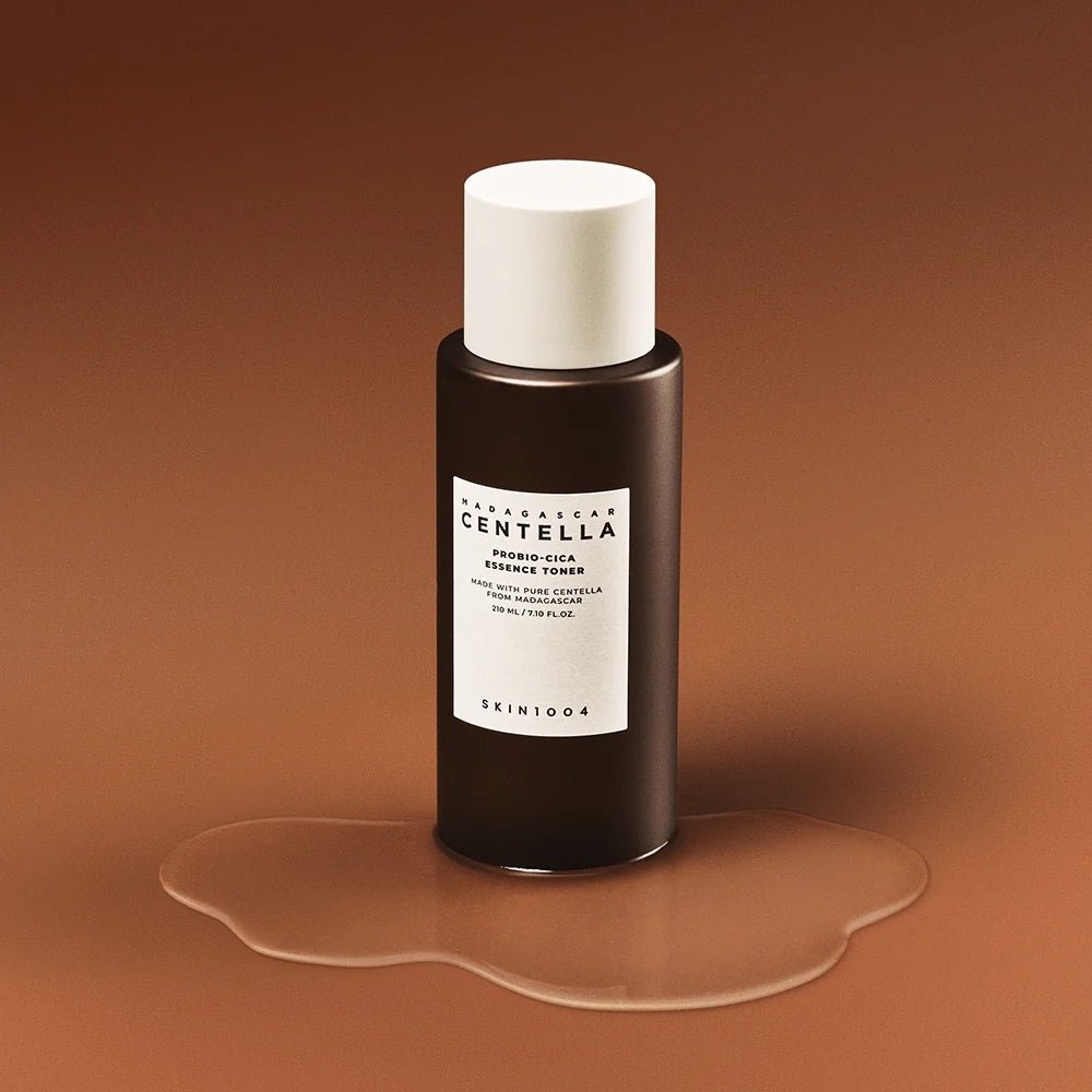 SKIN1004 Madagascar Centella Probio-cica Essence Toner 210ml, flacon sur fond brun chaud, peau hydratée, marque SKIN1004