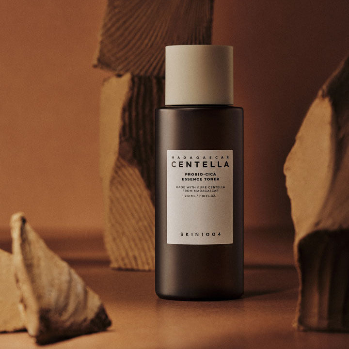 SKIN1004 Madagascar Centella Probio-cica Essence Toner 210ml de la marque SKIN1004, flacon noir sur fond chaleureux.