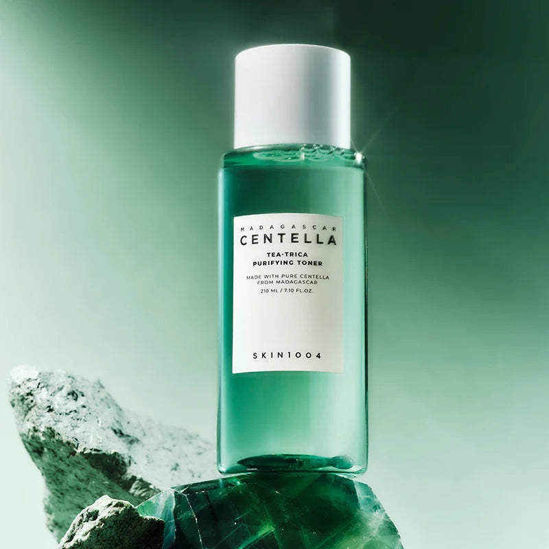 SKIN1004 Madagascar Centella Tea-trica Purifying Toner 210ml, produit SKIN1004 sur fond vert et pierres, contexte skincare.
