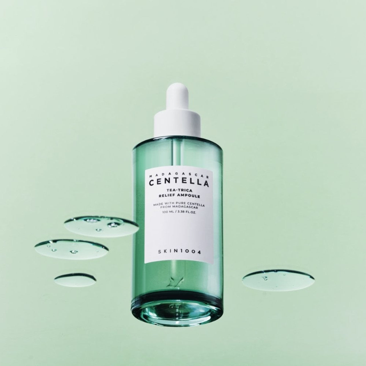 SKIN1004 Madagascar Centella Tea-trica Relief Ampoule 100ml de SKIN1004, flacon vert sur fond clair avec gouttes d’eau