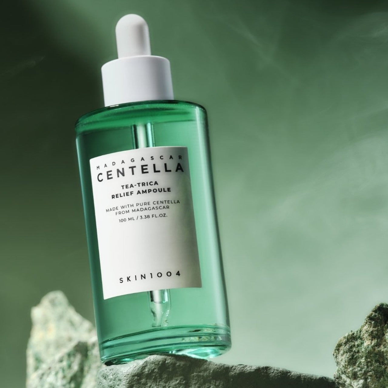 SKIN1004 Madagascar Centella Tea-trica Relief Ampoule 100ml, bouteille verte SKIN1004 sur fond vert, ambiance spa