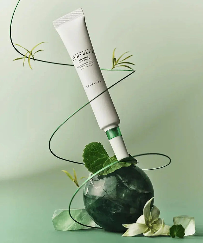 SKIN1004 Madagascar Centella Tea-trica Spot Cream 20ml de SKIN1004 sur fond vert, feuilles de centella et ambiance spa.