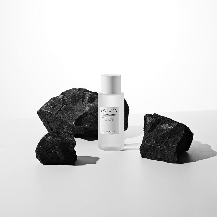 SKIN1004 Madagascar Centella Tone Brightening Boosting Toner 210ml, bouteille sur pierre noire, contexte beauté en studio