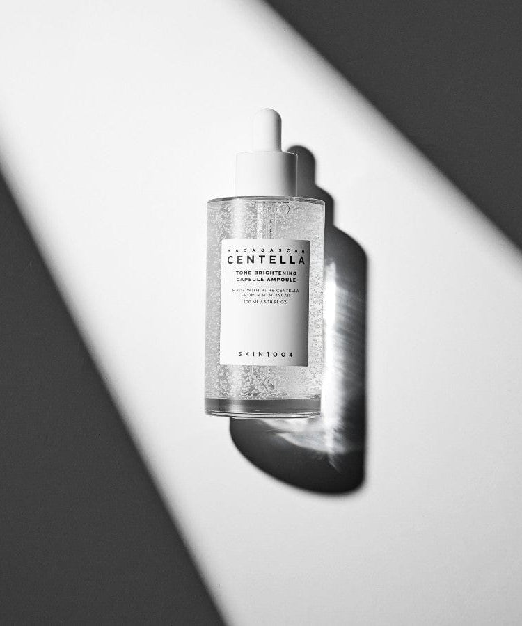 SKIN1004 Madagascar Centella Tone Brightening Capsule Ampoule 100ml, flacon sérum SKIN1004, fond noir et blanc, lumière studio.