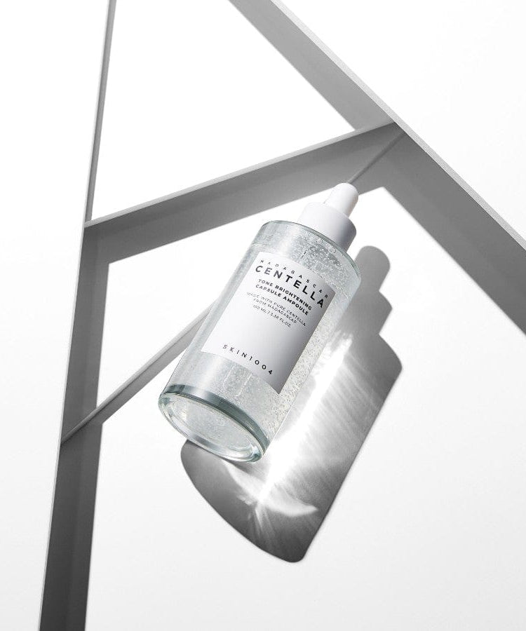 SKIN1004 Madagascar Centella Tone Brightening Capsule Ampoule 100ml de la marque SKIN1004, flacon dans décor géométrique blanc.