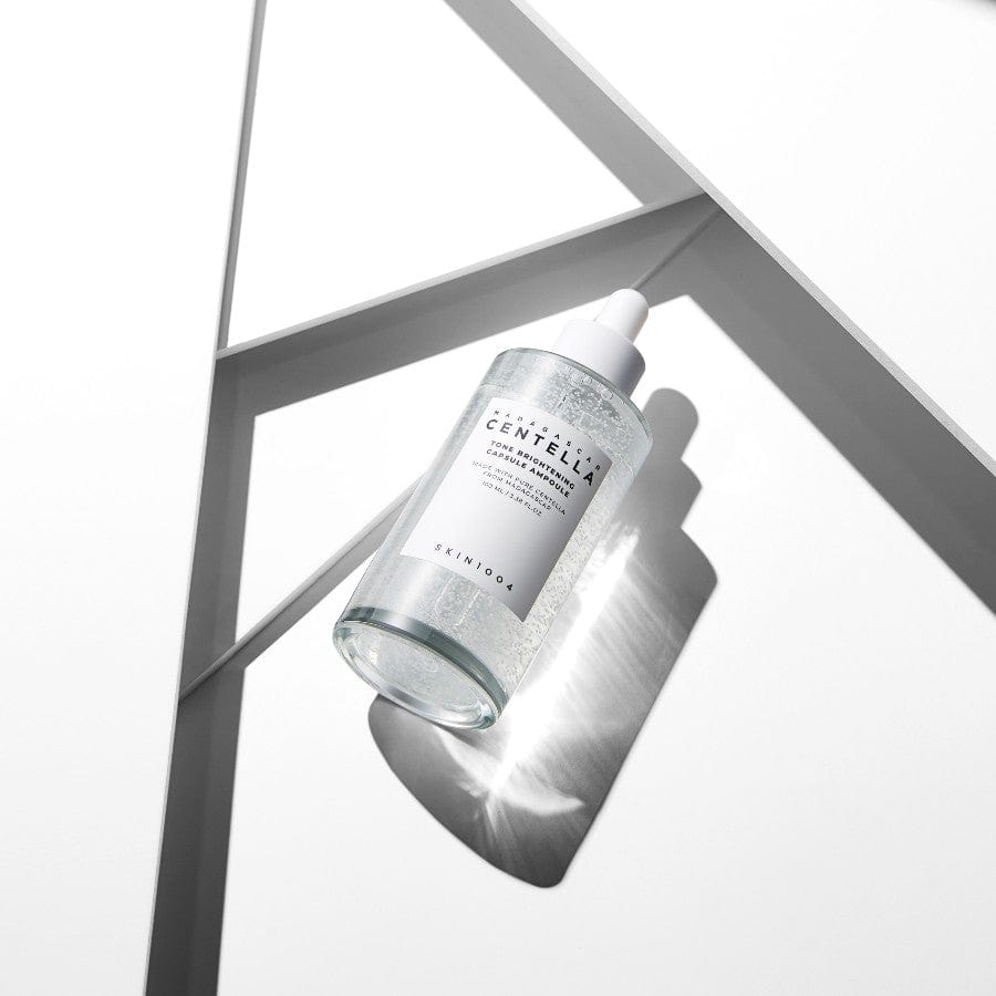 SKIN1004 Madagascar Centella Tone Brightening Capsule Ampoule 100ml de la marque SKIN1004, flacon dans décor géométrique blanc.