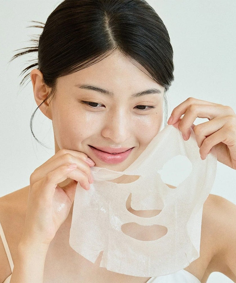 Femme appliquant SKIN1004 Madagascar Centella Tone Brightening Glow Mask 25ml [5 sheets] pour un teint lumineux et rafraîchi