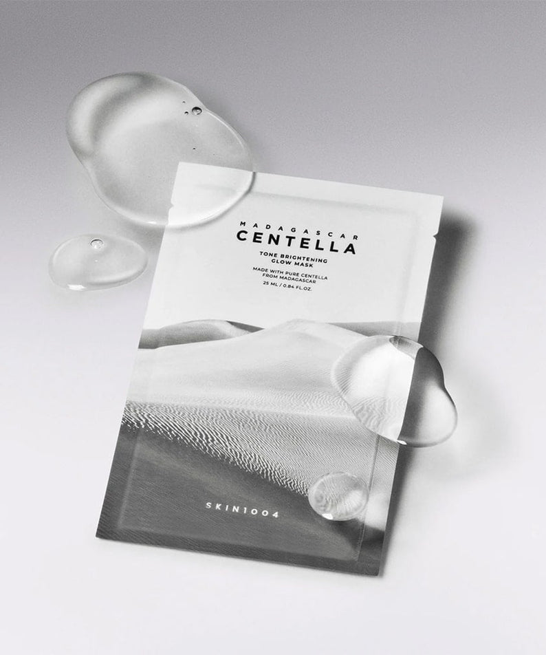 Masque "SKIN1004 Madagascar Centella Tone Brightening Glow Mask 25ml [5 sheets]" avec gouttelettes d'eau, vue de face