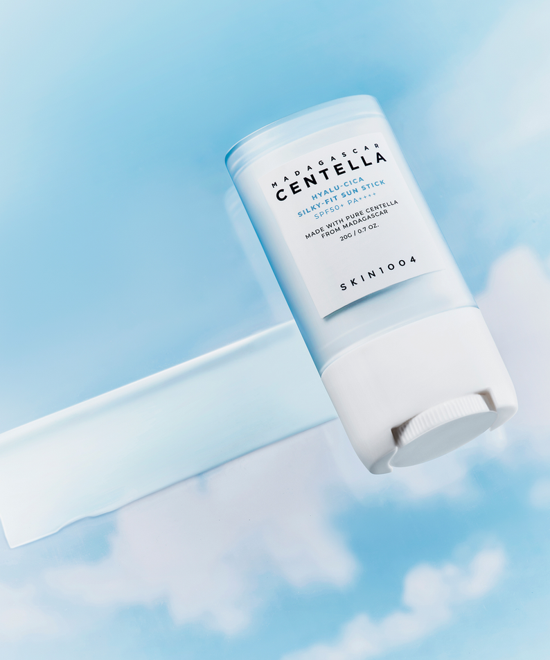 SKIN1004 Madagascar Centella Hyalu-Cica Silky Fit Sun Stick 20g en texture légère sur fond de ciel bleu.