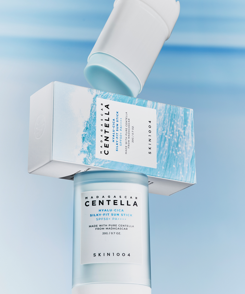 Bâton solaire SKIN1004 Madagascar Centella Hyalu-Cica Silky Fit 20g avec emballage, fond bleu océanique.