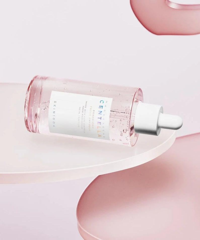 Image de SKIN1004 Madagascar Centella Pore-Mfying Fresh Ampoule 100ml sur une plateforme rose élégante.