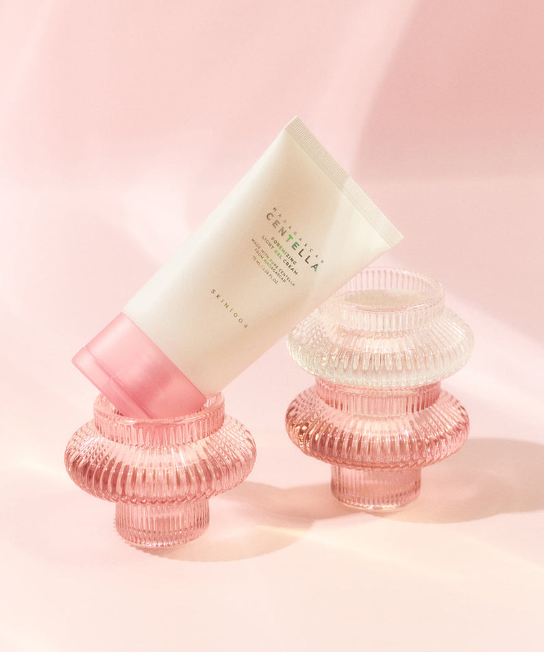 Crème légère SKIN1004 Madagascar Centella Poremizing 75ml posée sur des supports en verre rose sur un fond rose élégant.