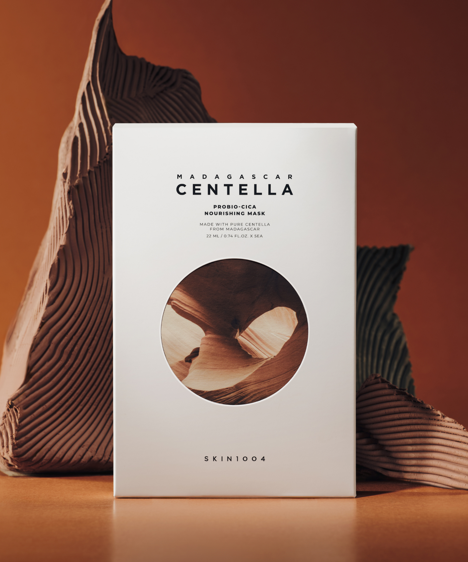 Masque SKIN1004 Madagascar Centella Probio-cica Nourishing Mask 22ml [5 sheets] présenté sur fond artistique brun