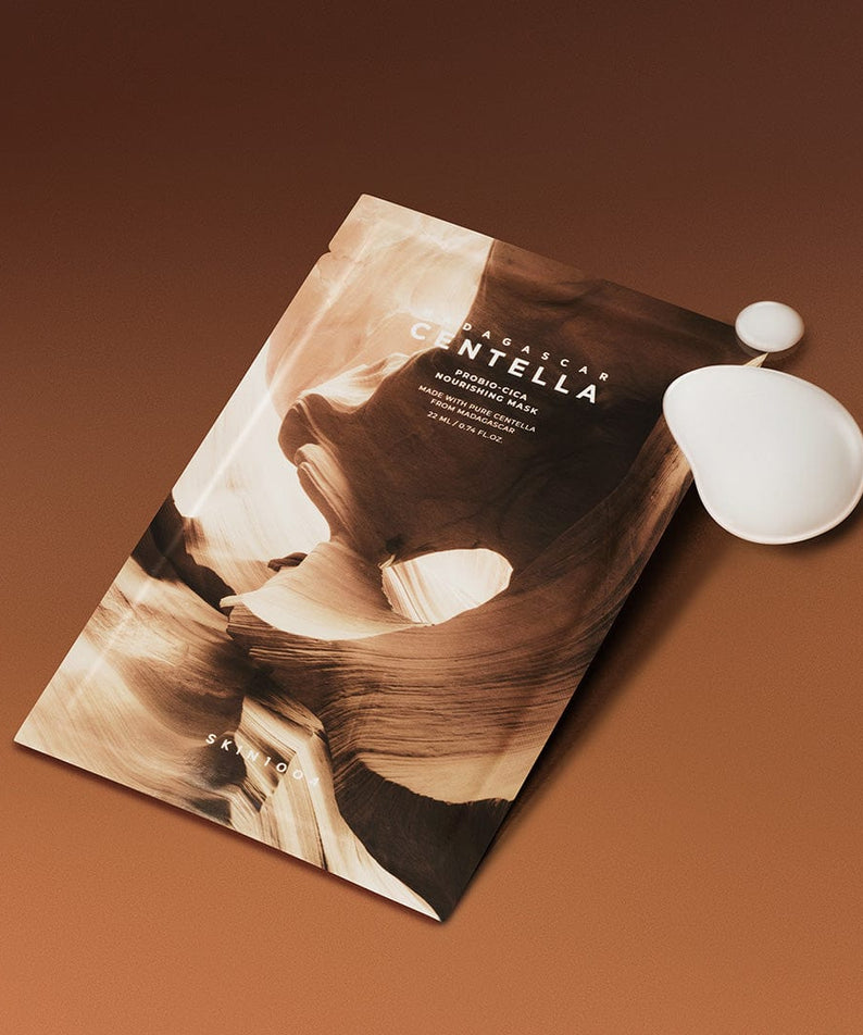 SKIN1004 Madagascar Centella Probio-cica Nourishing Mask 22ml [5 sheets] avec masque nourrissant et hydratant sur fond marron.