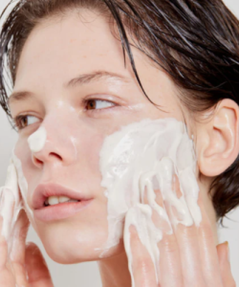 Personne appliquant SKIN1004 Madagascar Centella Tea-trica BHA Foam 125ml sur le visage pour un soin nettoyant en profondeur.