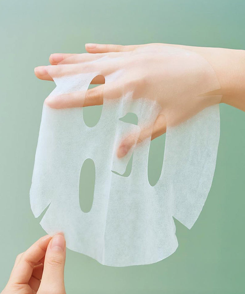 Masque relaxant SKIN1004 Madagascar Centella Tea-trica 24ml [5 feuilles] en cours d'application sur une main, vue de détail.